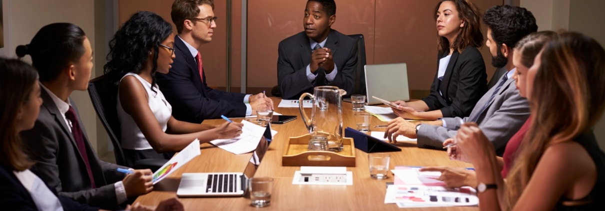 Diverse group of men and women sitting in a boardroom
