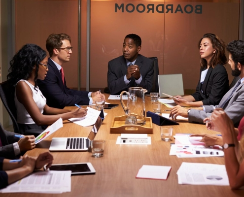 Diverse group of men and women sitting in a boardroom