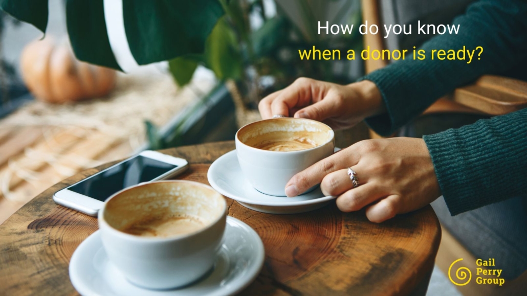 Two people meeting over coffee discussing nonprofit donor relationship and giving