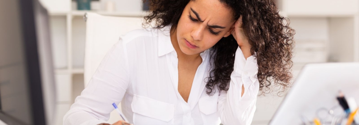 Nonprofit development director looking thoughtfully at a major gift prospect list, frustrated but determined