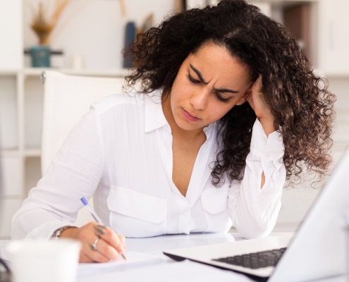 Nonprofit development director looking thoughtfully at a major gift prospect list, frustrated but determined