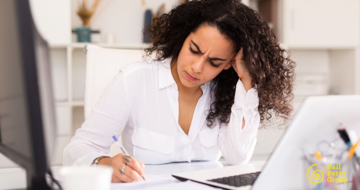 Nonprofit development director looking thoughtfully at a major gift prospect list, frustrated but determined
