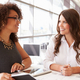 Two fundraising professionals reviewing donor relationships and discussing their work together.