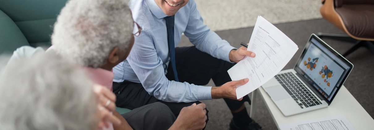 Financial advisor reviewing documents with an older client during a financial planning conversation.