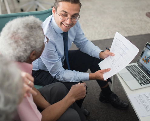 Financial advisor reviewing documents with an older client during a financial planning conversation.